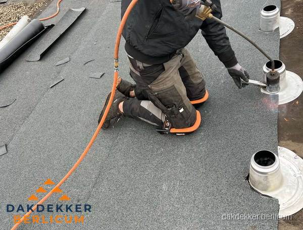 Dakdekker repareert bitumen dakleer bij dakdoorvoer in Berlicum Dakdekker repareert bitumen dakleer bij dakdoorvoer in Berlicum