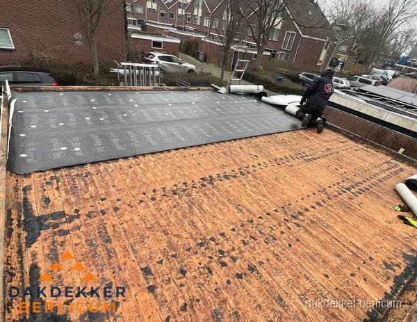 Dakdekker legt onderlaag op plat dak met houten constructie in Berlicum