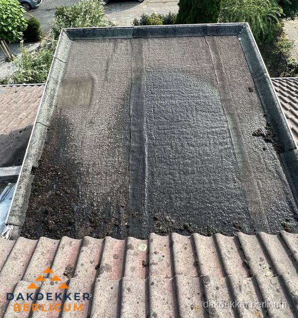 Verouderd plat dak met bitumen en slijtage voor lekkage inspectie in Berlicum Verouderd plat dak met bitumen en slijtage voor lekkage inspectie in Berlicum
