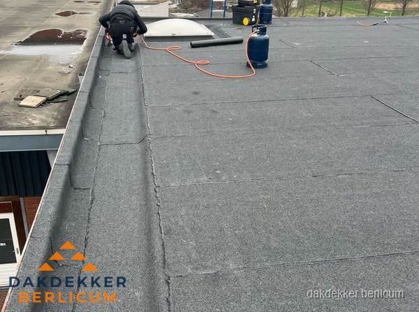 Dakdekker repareert bitumen dakbedekking op groot plat dak in Berlicum Dakdekker repareert bitumen dakbedekking op groot plat dak in Berlicum