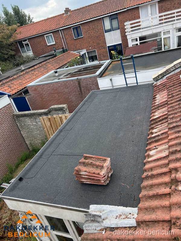 Plat dak aanbouw met bitumen naast schuin pannendak in Berlicum